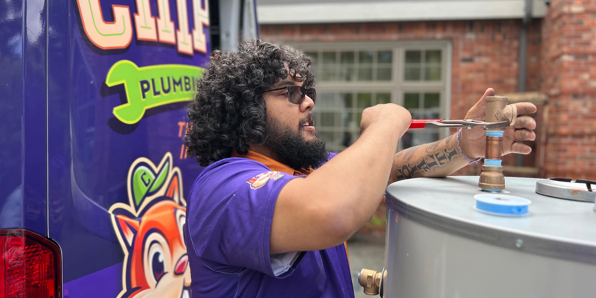 A Chipper Plumbing expert preparing a water heater by the Chipper van