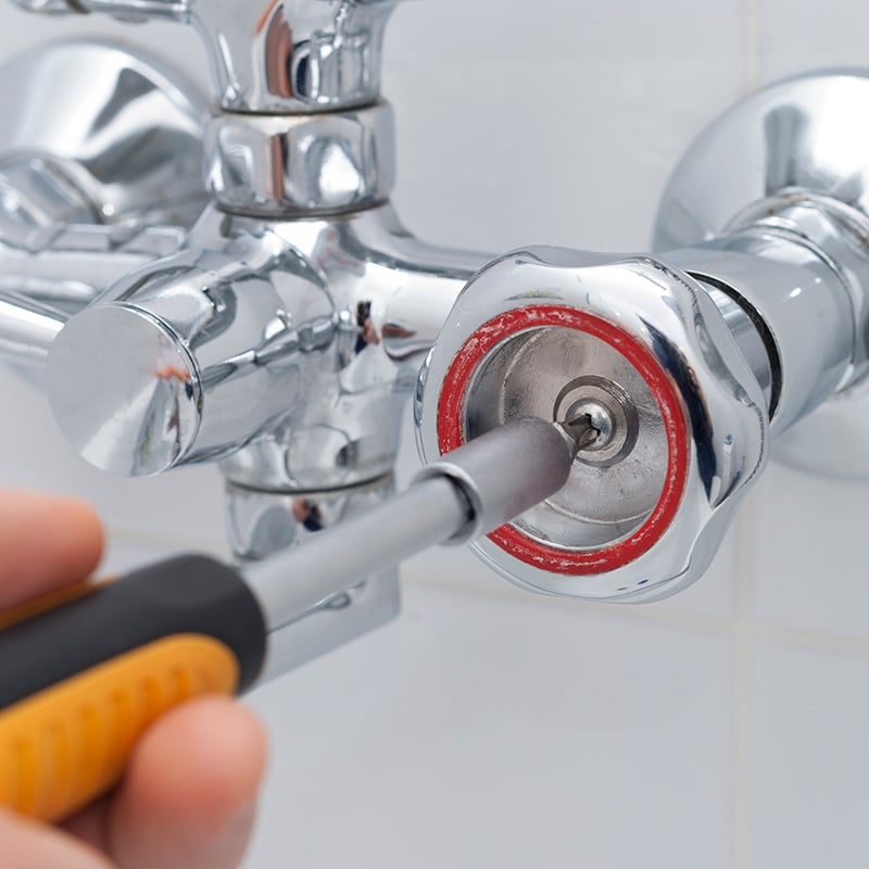 a Chipper Plumbing specialist tightening a bathtub shower faucet